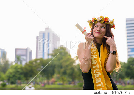 Young beautiful woman celebrating graduation at the park in Bang Young beautiful woman celebrating graduation at the park in Bang 61676017