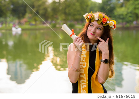 Young beautiful woman celebrating graduation at the park in Bang 61676019