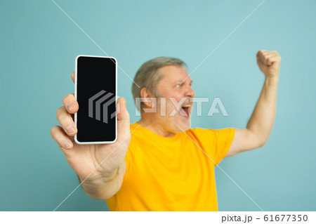 Caucasian senior man's portrait isolated on blue studio background Caucasian senior man's portrait isolated on blue studio background 61677350
