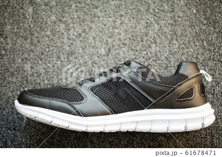 Pair of new stylish sneakers on floor at home. 61678471