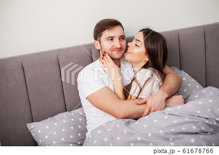 Loving couple relaxing in bed at home Loving couple relaxing in bed at home 61678766