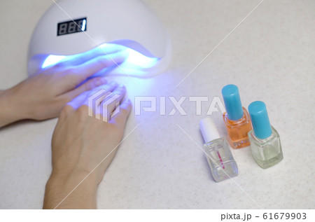 Hands of young woman at manicure procedure close 61679903