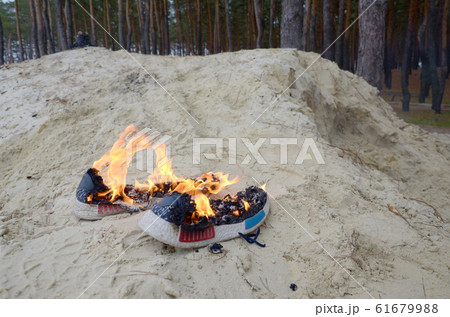 Burning sports sneakers or gym shoes on fire stand Burning sports sneakers or gym shoes on fire stand 61679988