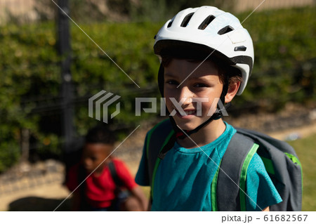 Schoolboy wearing a cycling helmet and riding a bicycle 61682567