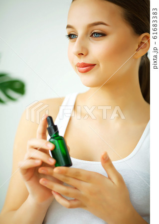 Beauty and Care. Portrait of a Young Woman with a Beautiful Skin. Girl Keeping Cream in Hands. Woman with Beautiful Blue Eyes. Cosmetics. Skin Care Beauty and Care. Portrait of a Young Woman with a Beautiful Skin. Girl Keeping Cream in Hands. Woman with Beautiful Blue Eyes. Cosmetics. Skin Care 61683383