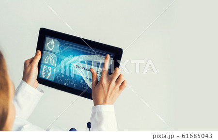 Close of female doctor hands working with tablet pc computer Close of female doctor hands working with tablet pc computer 61685043