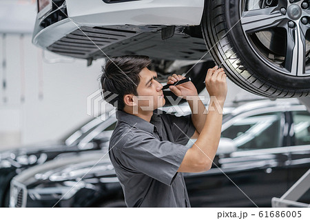 Asian mechanic Checking and torch tire in maintainance service center which is a part of showroom, technician or professional work for customer concept Asian mechanic Checking and torch tire in maintainance service center which is a part of showroom, technician or professional work for customer concept 61686005