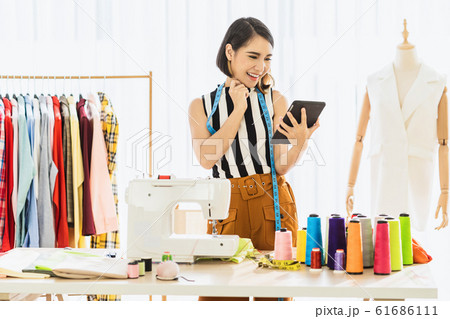 Portrait Young Asian Designer woman working and using the technology tablet at workplace over Clothes mannequins, small business startup, Business owner entrepreneur, modern freelance job lifestyle concept.asean people Portrait Young Asian Designer woman working and using the technology tablet at workplace over Clothes mannequins, small business startup, Business owner entrepreneur, modern freelance job lifestyle concept.asean people 61686111