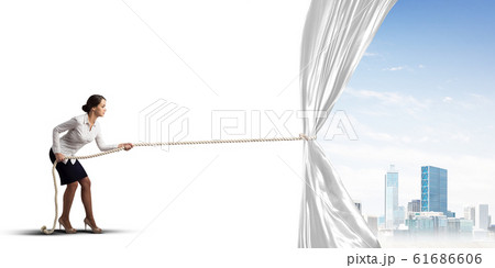 Young woman opening white curtain and presenting modern city landscape 61686606
