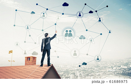 Businessman on house roof presenting networking and connection c 61686975