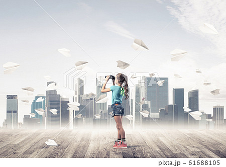 Concept of careless happy childhood with girl looking in binocul 61688105