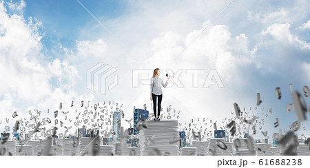 Woman keeping megaphone in hand. 61688238