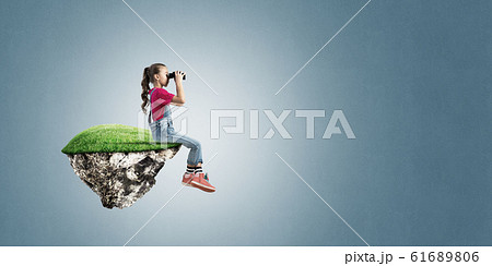 Concept of careless happy childhood with girl looking in binoculars Concept of careless happy childhood with girl looking in binoculars 61689806