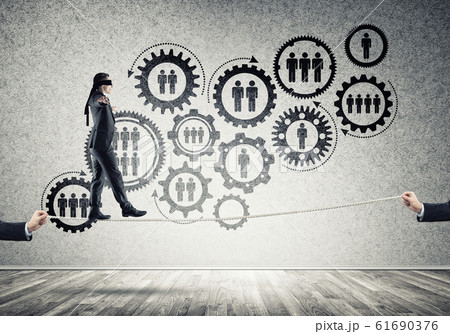 Business concept of risk support and assistance with man balancing on rope 61690376
