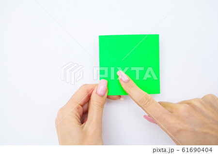 Office Hand Holding a Green Color Sticker on White Background. Copyspace. Place for Text 61690404