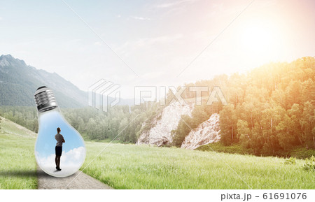 Businesswoman inside light bulb Businesswoman inside light bulb 61691076