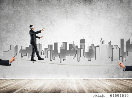 Business concept of risk support and assistance with man balancing on rope 61691616