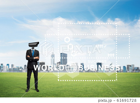 Camera headed man standing on green grass against modern cityscape Camera headed man standing on green grass against modern cityscape 61691728