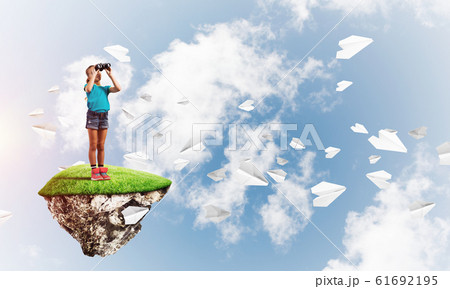 Concept of careless happy childhood with girl looking in binoculars 61692195