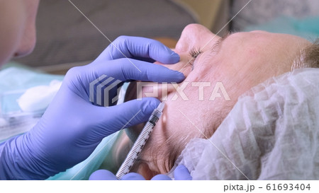 Woman getting cosmetic injection, closeup. Woman in beauty salon. plastic surgery clinic Woman getting cosmetic injection, closeup. Woman in beauty salon. plastic surgery clinic 61693404