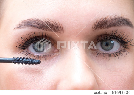 Female eyes with mascara brush. Female eyes with long eyelashes and a mascara brush. 61693580
