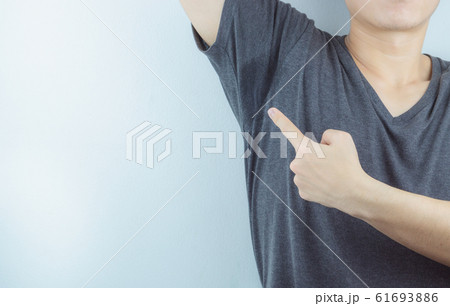 Closeup man with hyperhidrosis sweating very badly under armpit and left stain on his clothes. 61693886