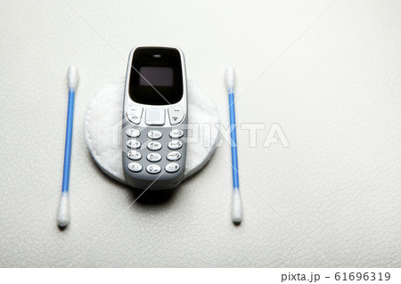 mobile phone ear stick cotton disk leather background mobile phone ear stick cotton disk leather background 61696319