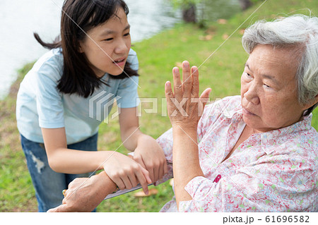 Unhappy asian child girl comfort upset offended senior grandmother,female teenager is stressed to trying to reconcile or compromise,elderly people looking away avoiding talking with granddaughter 61696582