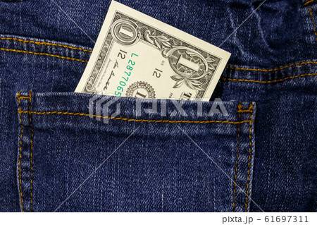 One dollar bill in a pocket of blue jeans One dollar bill in a pocket of blue jeans 61697311
