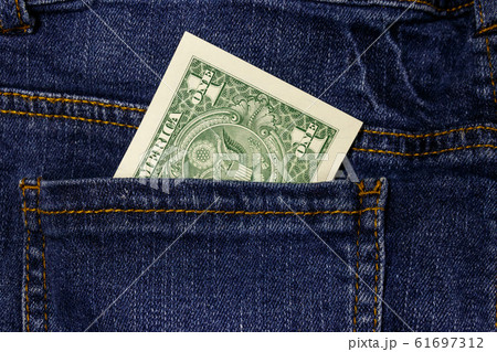 One dollar bill in a pocket of blue jeans One dollar bill in a pocket of blue jeans 61697312