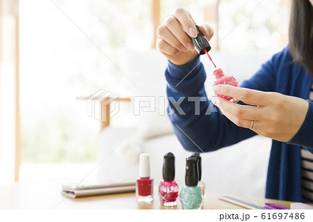 マニキュアを塗る若い女性手元 マニキュアを塗る若い女性手元 61697486