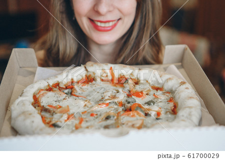 Portrait of a happy girl with a pizza in her hands. fast food advertising, confectionery, cooking, overeating, diet, Italian food Portrait of a happy girl with a pizza in her hands. fast food advertising, confectionery, cooking, overeating, diet, Italian food 61700029