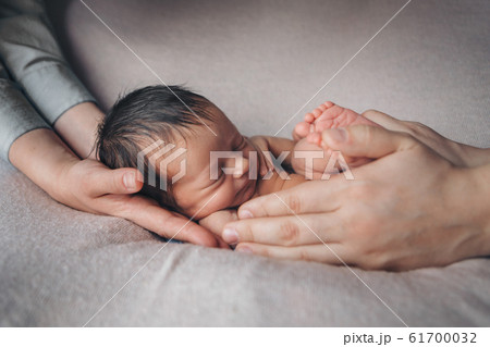 newborn baby lying on the hands of parents. Imitation of a baby in the womb. beautiful little girl sleeping lying on her back. manifestation of love. Health care concept, parenthood, children's Day, m newborn baby lying on the hands of parents. Imitation of a baby in the womb. beautiful little girl sleeping lying on her back. manifestation of love. Health care concept, parenthood, children's Day, m 61700032