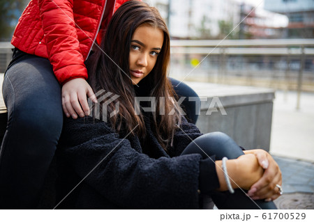 Close-up Portrait Of Best Friends Sitting Togehter In City Close-up Portrait Of Best Friends Sitting Togehter In City 61700529