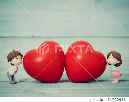 Closeup of couple cute dolls in love and two red heart on blue wooden background. Use for valentines day, love and relationship concept. Closeup of couple cute dolls in love and two red heart on blue wooden background. Use for valentines day, love and relationship concept. 61700951