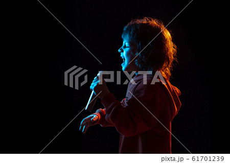 Caucasian boy's portrait isolated on dark studio background in neon light Caucasian boy's portrait isolated on dark studio background in neon light 61701239