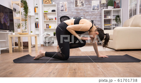 Side view of young woman doing yoga pose 61701738