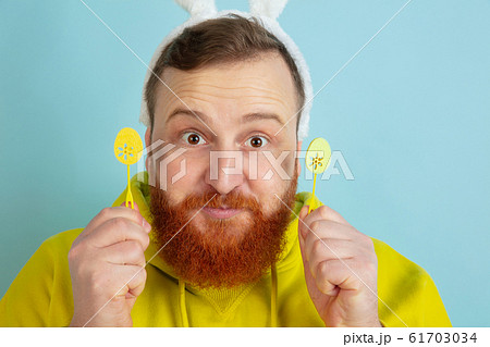 Easter bunny man with bright emotions on blue studio background 61703034