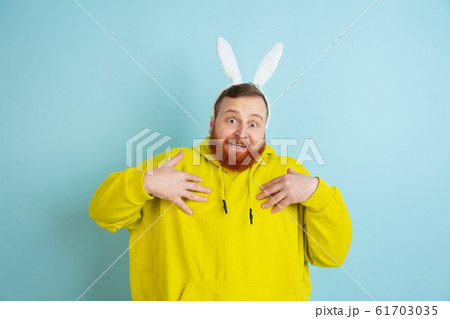 Easter bunny man with bright emotions on blue studio background 61703035