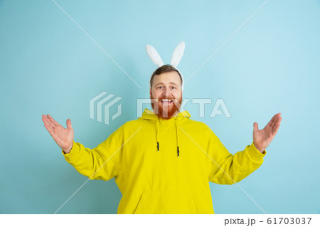Easter bunny man with bright emotions on blue studio background 61703037