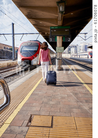 Traveler woman walking and waits train on railway Traveler woman walking and waits train on railway 61706078