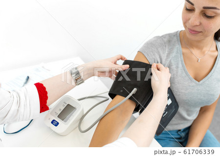 Physiotherapist puts on a medical tonometer to 61706339