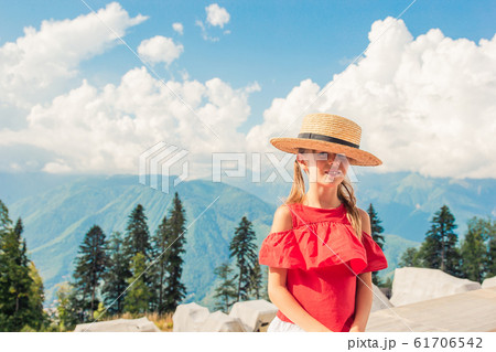 Beautiful happy little girl in mountains in the background of fog Beautiful happy little girl in mountains in the background of fog 61706542