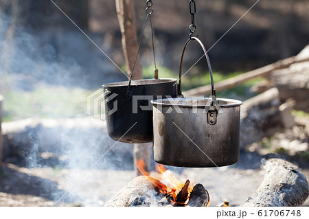 Cooking in two sooty old cauldrons on bonfire with Cooking in two sooty old cauldrons on bonfire with 61706748
