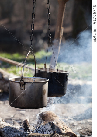 Two sooty old cauldrons on bonfire with smoke at Two sooty old cauldrons on bonfire with smoke at 61706749