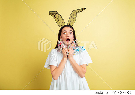 Easter bunny woman with bright emotions on yellow studio background Easter bunny woman with bright emotions on yellow studio background 61707239