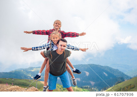 Beautiful kids and happy man in mountains in the background of fog 61707936