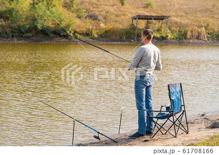 Man relaxing and fishing by lakeside a 61708166