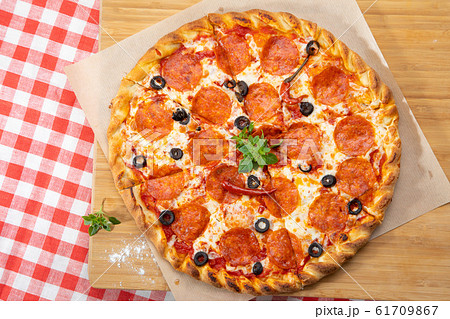 Pepperoni pizza close-up with various ingredients decorated with Basil 61709867
