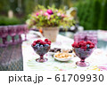 Beautiful glasses of colored purple glass on the table with berries and flowers 61709930